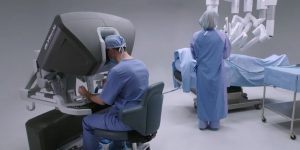 a doctor sits at a surgical robot