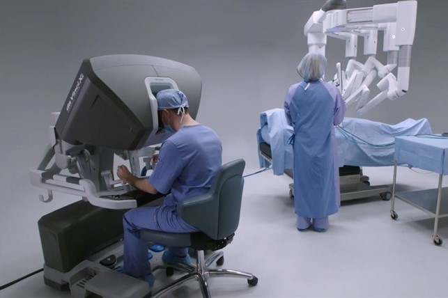 a doctor sits at a surgical robot