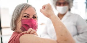 woman patient shows arm after receiving vaccine
