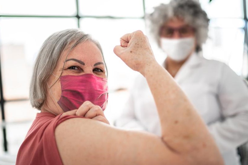 woman patient shows arm after receiving vaccine