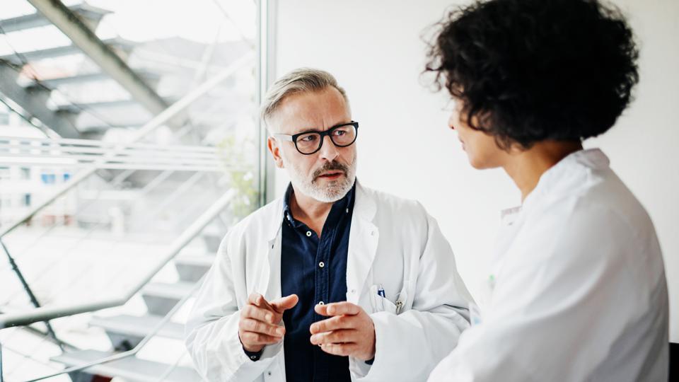 two physicians talking; one is a man and the other a woman